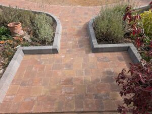 Completed block paving path between planting beds with grey kerb edging in Bexley